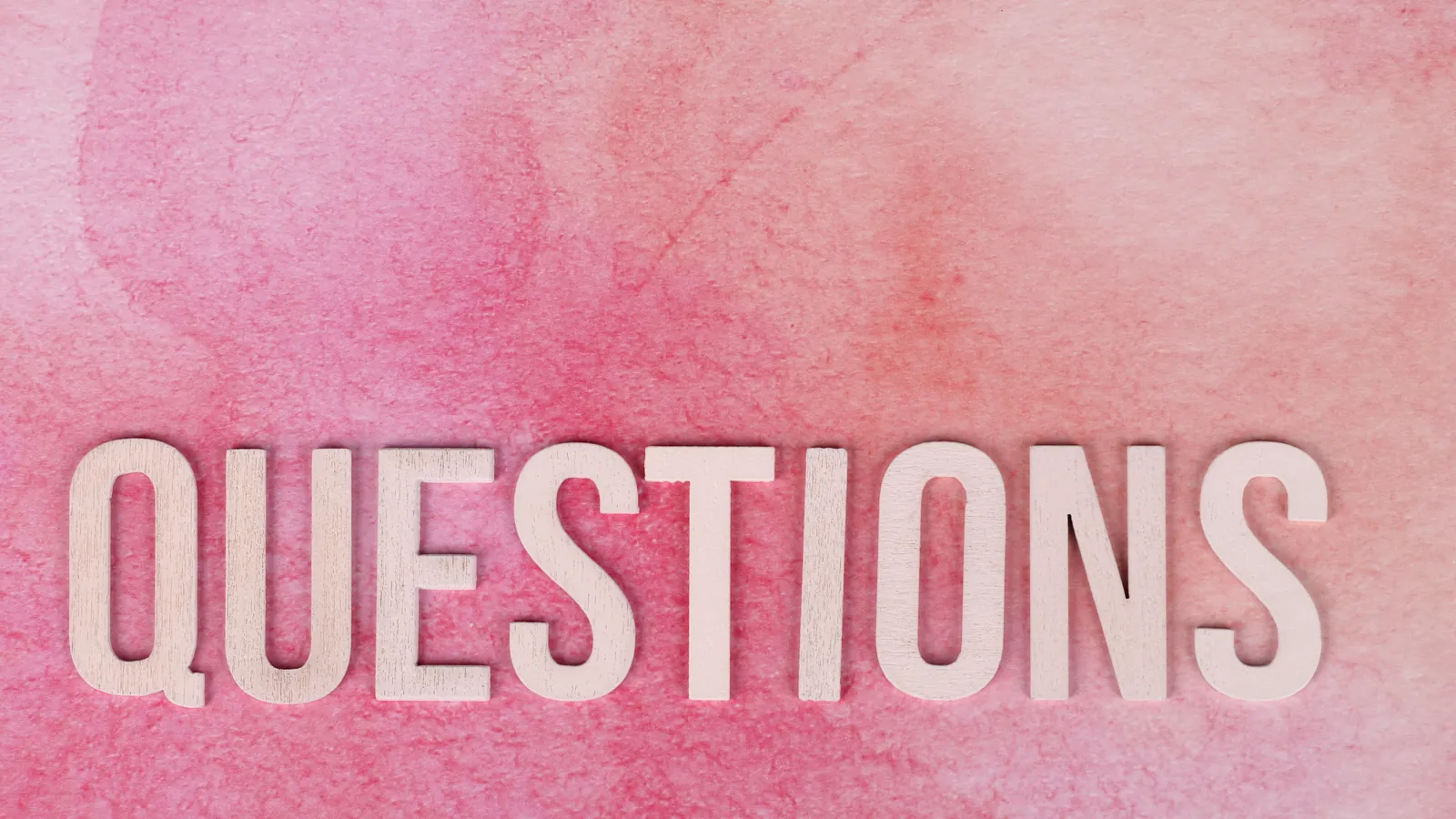粉紅色背景上以立體字母排出 QUESTIONS 一字